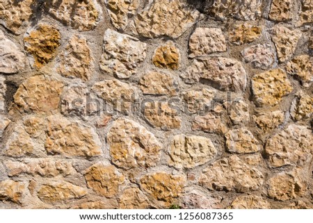 An old brown, orange and gray stone wall makes an excellent background