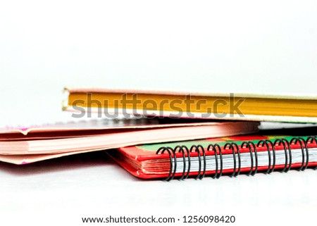 A Stack of Colorful Note Books on a White Background