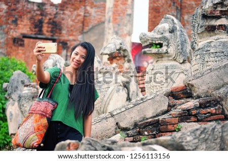 Asian tourist woman selfie at ancient of the temple thai architecture at Ayutthaya Historical Park,also UNESCO world heritage,Thailand. summer vacation,travel concept