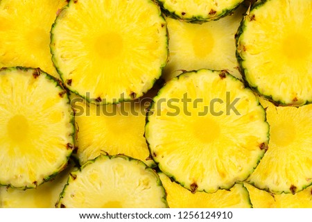 Pineapple juicy yellow slices background. Top view. Royalty-Free Stock Photo #1256124910