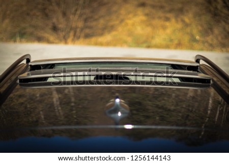 Double panoramic glazed dach open sunroof outside view. Tilted, open hatch - luxurious modern car isolated photo session in a parking lot. Close up photo, detailed.