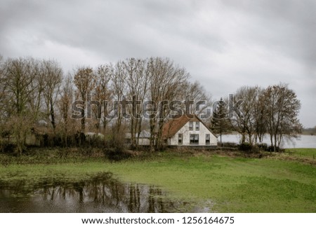 Moody picture of a Dutch farm near the river in winter. At the time this picture was taken the water was very high.
