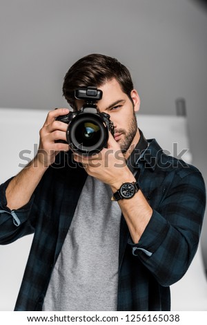 handsome young male photographer shooting with professional camera 