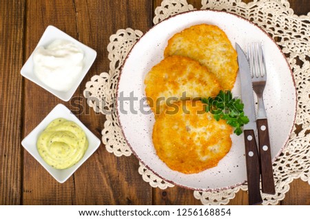 Vegetable rosti, golden fried potato pancakes with dips from cauliflower and sour cream. Studio Photo
