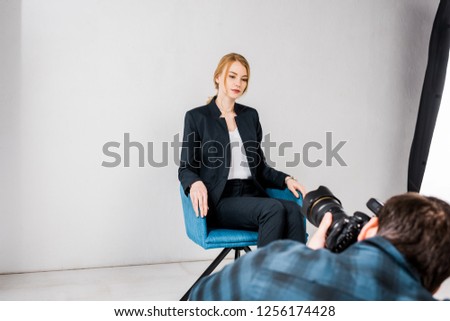 male photographer shooting beautiful young woman in photo studio   