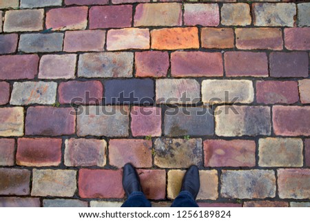  Abstract background of old cobblestone pavement and human legs