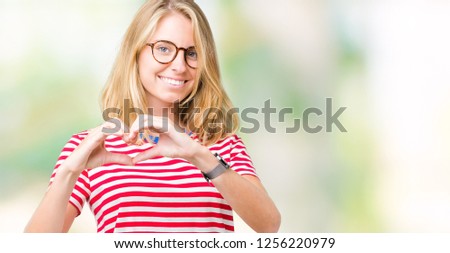 Beautiful young woman wearing glasses over isolated background smiling in love showing heart symbol and shape with hands. Romantic concept.