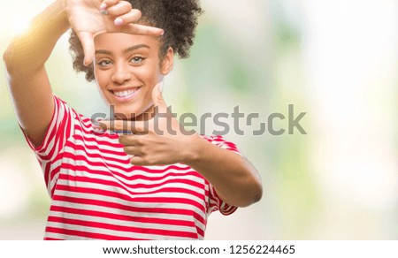 Young afro american woman over isolated background smiling making frame with hands and fingers with happy face. Creativity and photography concept.