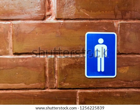 Men bathroom sign on brown tile wall.Male toilet sign.