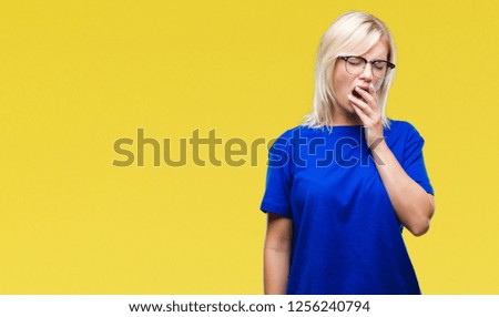 Young beautiful blonde woman wearing glasses over isolated background bored yawning tired covering mouth with hand. Restless and sleepiness.