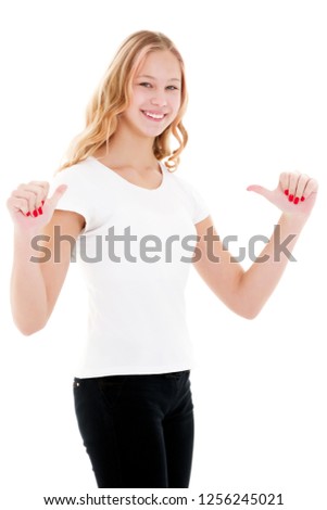 A nice little girl in a clean white T-shirt is pointing at something. The concept can be used to advertise goods and services whose logo can be printed on the surface of a shirt. Isolated on white