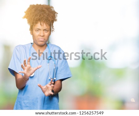 Young african american doctor woman over isolated background disgusted expression, displeased and fearful doing disgust face because aversion reaction. With hands raised. Annoying concept.