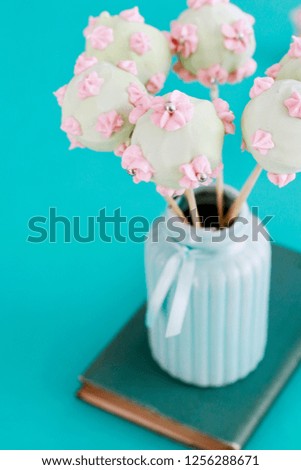 Cake pops decorated with pink cream. 
