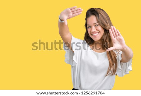 Young beautiful brunette business woman over isolated background Smiling doing frame using hands palms and fingers, camera perspective