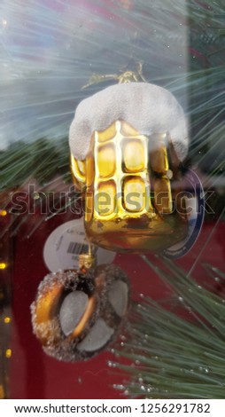 Glass Christmas ornaments in shapes of shiny golden beer mug with pretzel. Winter holiday decor. Christmas glittering decorations. Christmas fair in Berlin Germany. New Year celebration. 