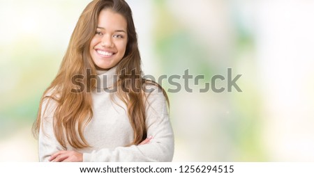 Young beautiful brunette woman wearing turtleneck sweater over isolated background happy face smiling with crossed arms looking at the camera. Positive person.