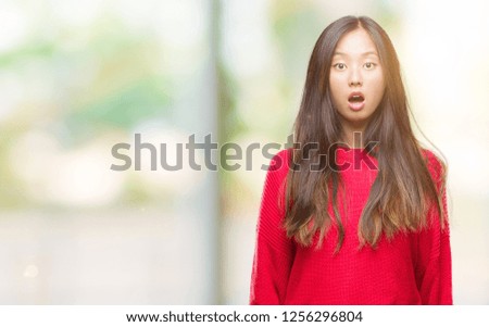 Young asian woman wearing winter sweater over isolated background afraid and shocked with surprise expression, fear and excited face.
