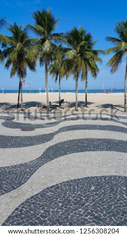 Copacabana Beach Rio de Janeiro boardwalk with palm trees and bl