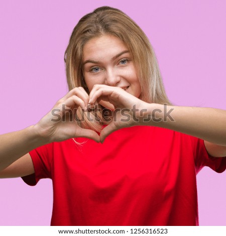 Young caucasian woman over isolated background smiling in love showing heart symbol and shape with hands. Romantic concept.