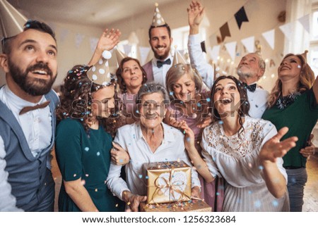 A portrait of multigeneration family with presents on a indoor birthday party. Royalty-Free Stock Photo #1256323684