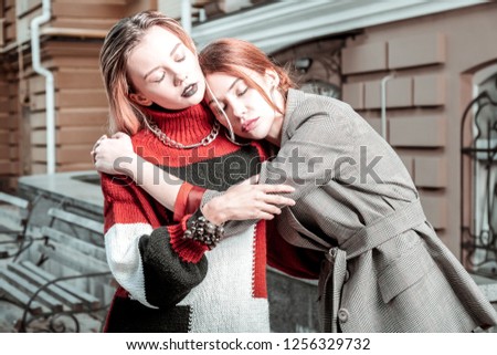 Rested and relieved. Two fashionable young women hugging feeling rested and relieved after finishing work