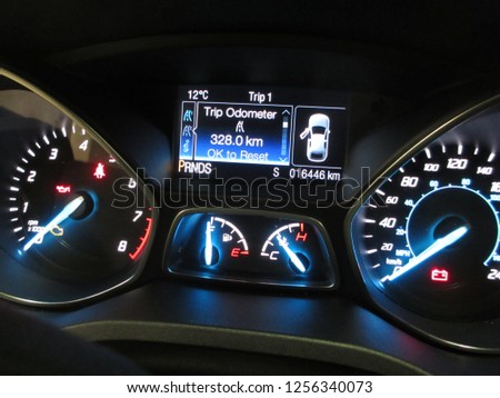 A picture was taken from a modern rental car dashboard to document the mileage for preventive legal purposes in our litigation happy society. The modest design is straightforward with no clutter.