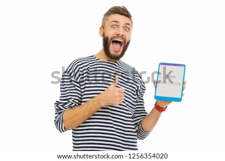 Quick search. Happy delighted man showing thumbs up gesture while enjoying using a search website