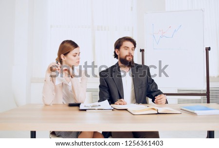 A man and a woman are sitting at the table and working                