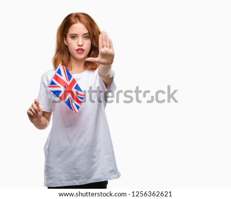 Young beautiful woman holding flag of united kingdom over isolated background with open hand doing stop sign with serious and confident expression, defense gesture