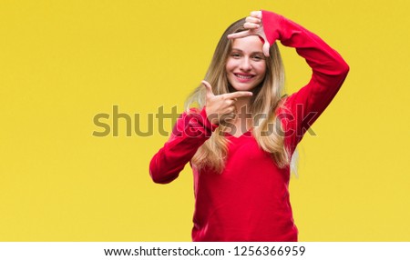 Young beautiful blonde woman wearing red sweater over isolated background smiling making frame with hands and fingers with happy face. Creativity and photography concept.