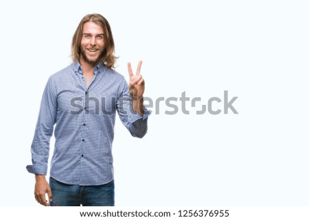 Young handsome man with long hair over isolated background smiling with happy face winking at the camera doing victory sign. Number two.