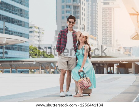 Travel tourist standing with luggage looking map in smartphone at the city. 
Travelers using gps map for sightseeing in town.
Couple tourist walking with luggage and travel in city.
Travel lifestyle.