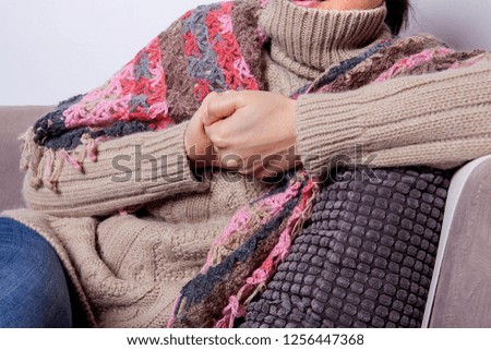 Woman feeling freeze and wrap up in a blanket.