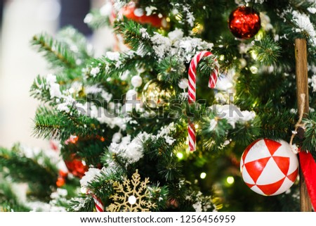 Image of Christmas tree with red balls, caramel canes, gift, golden snowflakes .