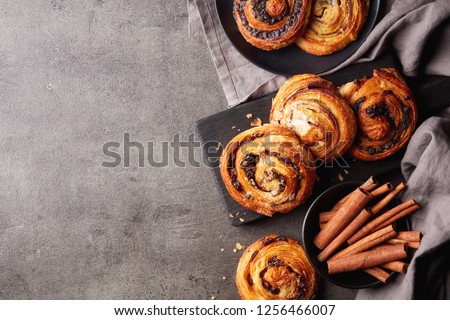 Freshly baked sweet buns on black board on grey stone background, top view Royalty-Free Stock Photo #1256466007