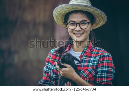 Attractive girl smiling and hugging a rabbit.