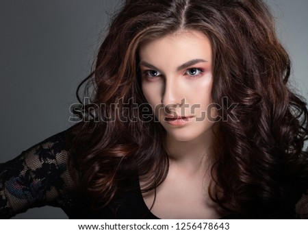 Fashionable photo of a beautiful young woman with luxurious dark hair.