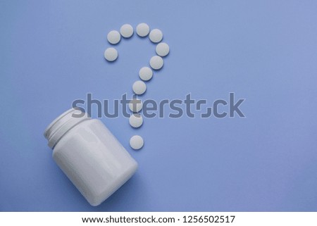 Medicines are white, round pills with a core, isolated on a purple background. tablets are presented in the form of a question mark.
