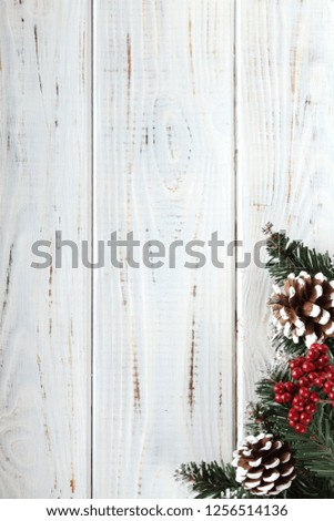 Spruce branches, cones and red berries on a white wooden background. Background for christmas and new year