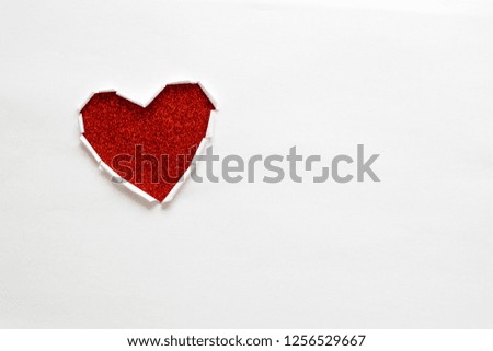 Ripped paper hole heart shaped on white paper background. Valentine's day celebration concept