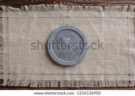 gray concrete round signboard on light linen fabric and wooden brown background