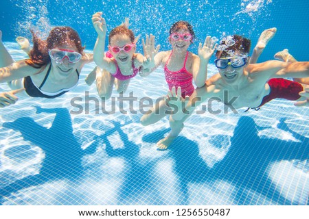 underwater photo of young family with kids in swimming  pool