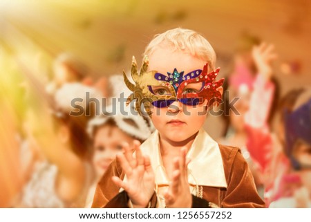 beautiful happy boy in carnival costume on the feast of the Nativity claps