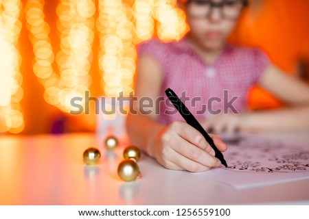 Close-up hand with pencil drawing christmas pictures. New year theme, bokeh and golden balls.