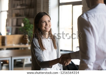 Excited girl intern handshaking executive manager getting hired rewarded, happy young employee proud to be promoted shake hands with boss congratulating successful worker, respect recognition concept Royalty-Free Stock Photo #1256564314