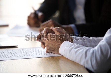 Lawyer solicitor with clasped hands consulting client about document making financial legal deal sell law services, close up view of business counselor or agreement party at contract signing concept