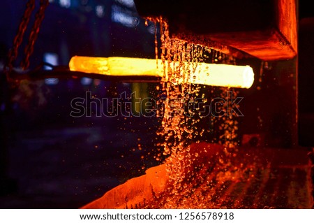 Steel quenching at high temperature in industrial furnace at the workshop of a forge plant. Process of cooling, heat treatmen. Blacksmith and metallurgical industry, steelmaking, hot rolling mill Royalty-Free Stock Photo #1256578918