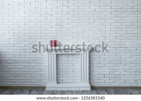 Beautiful interior in retro style. Beautiful and minimalistic interior with a white brick wall and a white fireplace with candles on it.