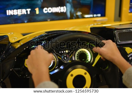 Teenager plays on gaming machine simulator car in the club Royalty-Free Stock Photo #1256595730