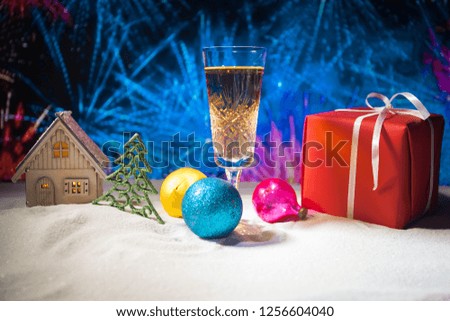 Glass of champagne with Christmas decoration. Traditional winter holiday alcohol drink in snow with creative New Year artwork. Copy space